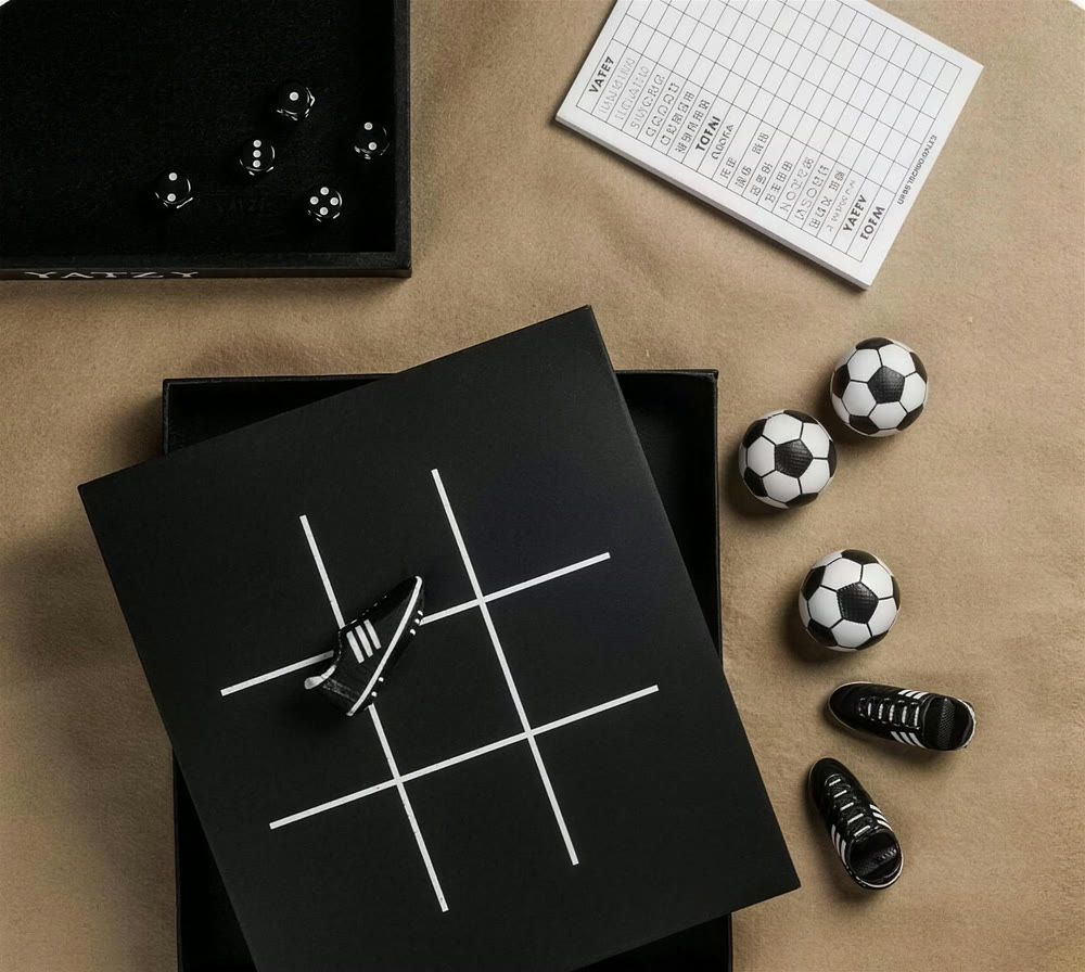 Svart tre i rad-bräde spelat med små fotbollar och fotbollsskor